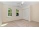 Comfortable bedroom with ceiling fan, neutral carpet, two windows, and a double-door closet at 122 N Fern Abbey Ln, Cary, NC 27518