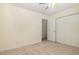 A carpeted bedroom featuring a ceiling fan, closet, and two windows for natural light at 122 N Fern Abbey Ln, Cary, NC 27518