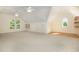 Expansive bonus room with two ceiling fans, wood shelving, hardwood floors, and natural light at 122 N Fern Abbey Ln, Cary, NC 27518