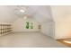 Spacious bonus room with neutral carpet, two ceiling fans and wood shelving at 122 N Fern Abbey Ln, Cary, NC 27518