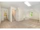 Large bonus room with neutral carpet, natural light, and access to stairs and hallway at 122 N Fern Abbey Ln, Cary, NC 27518