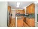 Well-equipped kitchen featuring ample counter space, stainless steel refrigerator, and warm wood cabinetry at 122 N Fern Abbey Ln, Cary, NC 27518