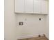 Functional laundry area with bright white cabinets for storage and wood-look floors at 122 N Fern Abbey Ln, Cary, NC 27518