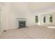 Living room with neutral carpet, fireplace, and several windows for natural light at 122 N Fern Abbey Ln, Cary, NC 27518