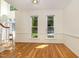 Living room with hardwood floors, white trim, wainscotting and large windows at 122 N Fern Abbey Ln, Cary, NC 27518