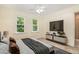 Relaxing bedroom with a ceiling fan, natural light, and a modern entertainment setup, offering comfort and style at 122 N Fern Abbey Ln, Cary, NC 27518