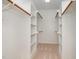 Spacious walk-in closet with wooden clothes rods and adjustable shelves, offering ample storage and organization at 122 N Fern Abbey Ln, Cary, NC 27518