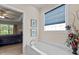 Well-lit primary bathroom featuring a garden tub with a window view at 1224 Wedgeland Dr, Raleigh, NC 27615