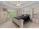 Inviting bedroom with tray ceiling, ceiling fan, and large window at 1224 Wedgeland Dr, Raleigh, NC 27615