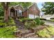 Charming brick home with landscaped front yard and stone staircase leading to the entrance at 1224 Wedgeland Dr, Raleigh, NC 27615