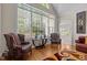Bright living room with large windows, hardwood floors, and comfortable chairs at 1224 Wedgeland Dr, Raleigh, NC 27615