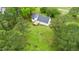 Wide angle view of a house with a spacious yard surrounded by lush trees and with a small back deck at 124 Windmere Dr, Angier, NC 27501