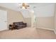 A cozy bedroom with carpet, neutral walls, a ceiling fan, and a plaid sofa at 124 Windmere Dr, Angier, NC 27501