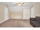 A carpeted bedroom with neutral walls, a ceiling fan, and a plaid sofa at 124 Windmere Dr, Angier, NC 27501