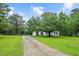 Traditional home with a long driveway and mature trees creating a serene setting at 124 Windmere Dr, Angier, NC 27501