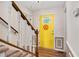Inviting foyer with a bright yellow door featuring decorative glass and a staircase with wooden banisters at 124 Windmere Dr, Angier, NC 27501