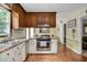 Well-lit kitchen featuring white lower cabinets, wood upper cabinets, and stainless steel appliances at 124 Windmere Dr, Angier, NC 27501