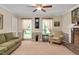 Bright living room with a ceiling fan, decorative curtains, and neutral decor, creating a welcoming space at 124 Windmere Dr, Angier, NC 27501