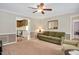 Comfortable living room with tan walls, wainscoting, and a view into the kitchen and a side room at 124 Windmere Dr, Angier, NC 27501