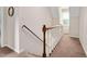 A staircase with carpet and a wooden handrail leads upstairs in this home at 124 Windmere Dr, Angier, NC 27501