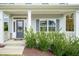 Inviting front porch with a dark blue door and beautifully landscaped green bushes at 131 River Chapel Dr, Fuquay Varina, NC 27526