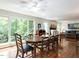 Open dining area featuring hardwood floors, a wooden table, and large windows offering beautiful outdoor views at 1514 John Jones Rd, Bahama, NC 27503