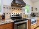 Close-up of a modern kitchen with stainless steel appliances, granite countertops, and custom cabinetry at 1514 John Jones Rd, Bahama, NC 27503