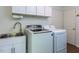 Functional laundry room with modern washer, dryer, sink, and ample storage in white cabinets at 1514 John Jones Rd, Bahama, NC 27503
