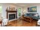 Cozy living room featuring a fireplace, hardwood floors, and comfortable seating with natural light from the windows at 1514 John Jones Rd, Bahama, NC 27503