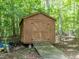Wooden shed with a ramp in a wooded area provides extra storage at 1514 John Jones Rd, Bahama, NC 27503