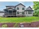 Expansive backyard featuring a screened deck, arched windows, and lush landscaping at 1540 Sandybrook Ln, Wake Forest, NC 27587