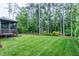Well-maintained backyard with lush green grass and mature trees, providing a serene outdoor space at 1540 Sandybrook Ln, Wake Forest, NC 27587