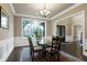 Elegant dining room with hardwood floors, wainscoting, a glass-top table, and a large window offering natural light at 1540 Sandybrook Ln, Wake Forest, NC 27587