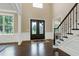 Spacious foyer boasting dark hardwood floors, a grand staircase, and a view of the elegant double front doors at 1540 Sandybrook Ln, Wake Forest, NC 27587