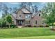 Beautiful brick home featuring manicured landscaping, a stone facade, and a covered front entrance at 1540 Sandybrook Ln, Wake Forest, NC 27587