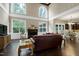 Sunlit living room featuring soaring ceilings, large windows, a fireplace, and dark hardwood floors at 1540 Sandybrook Ln, Wake Forest, NC 27587