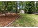 Lush backyard with mature trees and landscaping, providing a private outdoor retreat with a storage shed at 1605 Hall Blvd, Garner, NC 27529