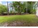 Expansive backyard with lush grass, mature trees, and a playground set at 1605 Hall Blvd, Garner, NC 27529