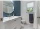 Stylish bathroom features a modern vanity, a round mirror, and neutral tiling at 1605 Hall Blvd, Garner, NC 27529
