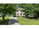 Traditional home with a well-manicured lawn, mature trees, and a paved driveway at 1605 Hall Blvd, Garner, NC 27529
