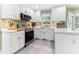 Bright kitchen features white cabinets, stainless steel appliances, and modern countertops at 1605 Hall Blvd, Garner, NC 27529