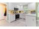 Bright kitchen features white cabinets, stainless steel appliances, and modern countertops at 1605 Hall Blvd, Garner, NC 27529