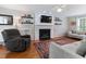 Relaxing living room featuring a fireplace with mantel, hardwood floors, ceiling fan, and neutral seating at 1605 Hall Blvd, Garner, NC 27529
