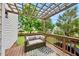 Inviting back deck under a pergola with cozy seating and a view of the landscaped backyard at 1605 Old London Way, Apex, NC 27523