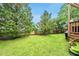 Expansive backyard featuring a well-manicured lawn, mature trees, and a charming wooden fence at 1605 Old London Way, Apex, NC 27523