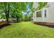 Lush backyard with mature trees, well-kept lawn, and landscaped borders, offering a private outdoor space at 1605 Old London Way, Apex, NC 27523