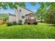 Large backyard featuring a deck with pergola, lush lawn, and manicured landscaping at 1605 Old London Way, Apex, NC 27523