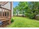 Well-maintained backyard with a lush lawn, mature trees, and a view of the deck and house at 1605 Old London Way, Apex, NC 27523
