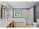 Bathroom featuring a tub, shower, and window providing natural light and a view of the outdoors at 1605 Old London Way, Apex, NC 27523