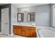 Bathroom featuring double sinks, a soaking tub, and elegant lighting fixtures for a luxurious feel at 1605 Old London Way, Apex, NC 27523